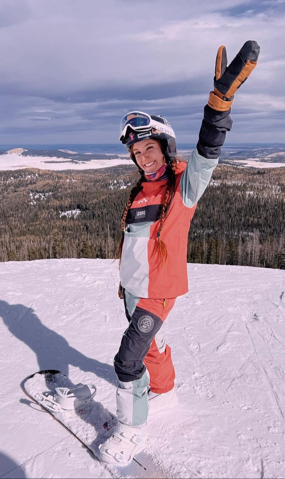 Person in ski gear with skis on a snowy slope with a scenic background